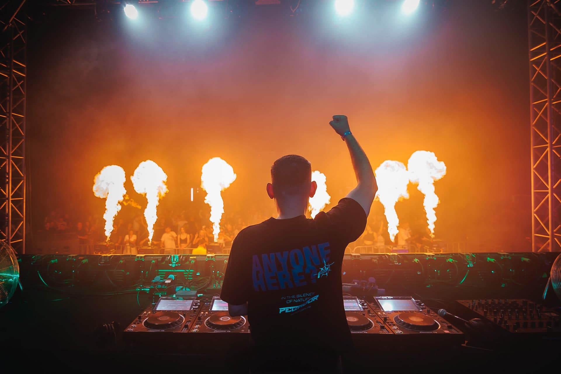 DJ przed publicznością, słupy ognia z rampy podczas imprezy