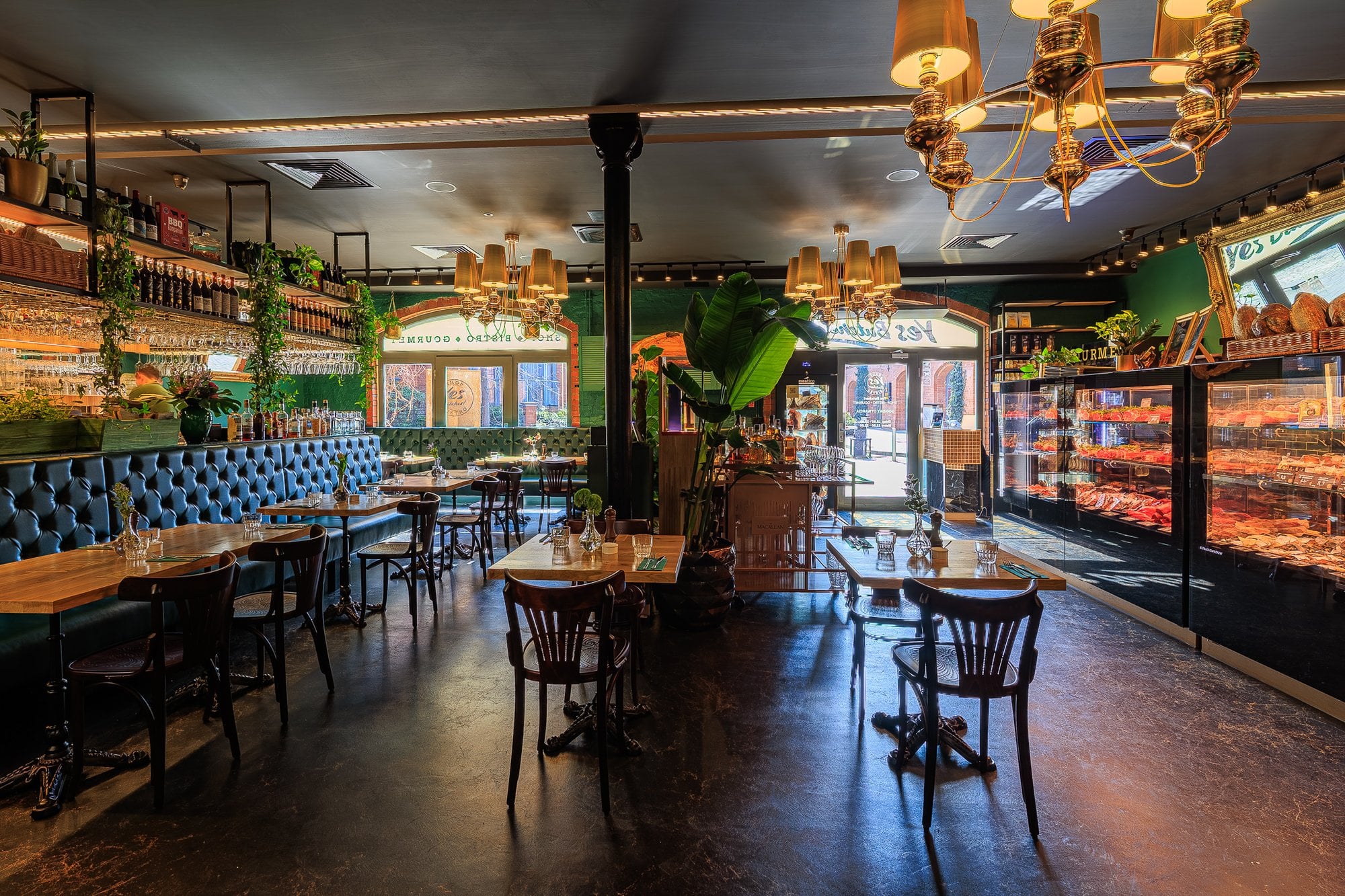 Sala główna bistro ze złotymi żyrandolami i ladą mięsną, zdjęcia wnętrz dla gastronomii
